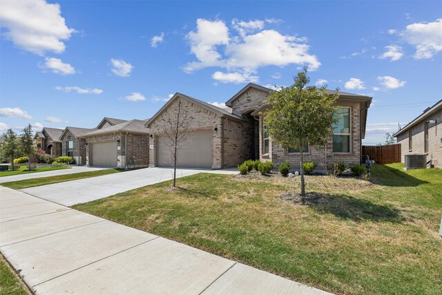 view of front of home featuring a front yard, central AC, and a garage