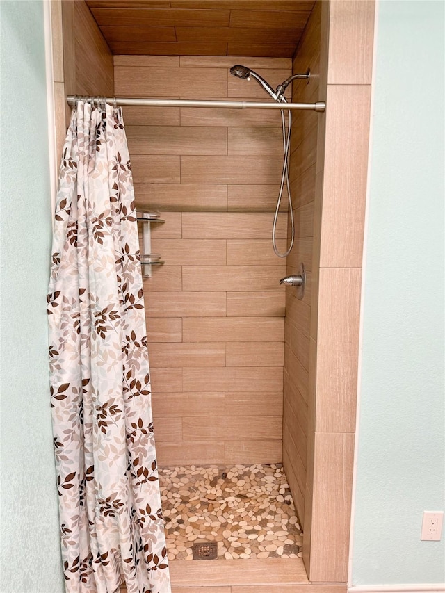 full bathroom featuring a shower stall and wood ceiling