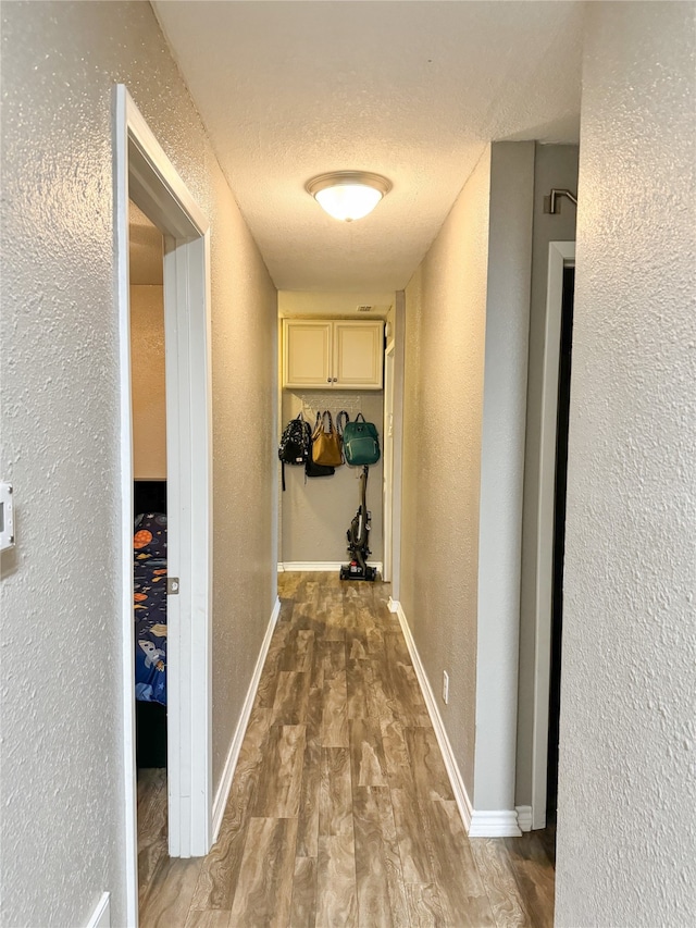 hallway featuring a textured ceiling and hardwood / wood-style flooring