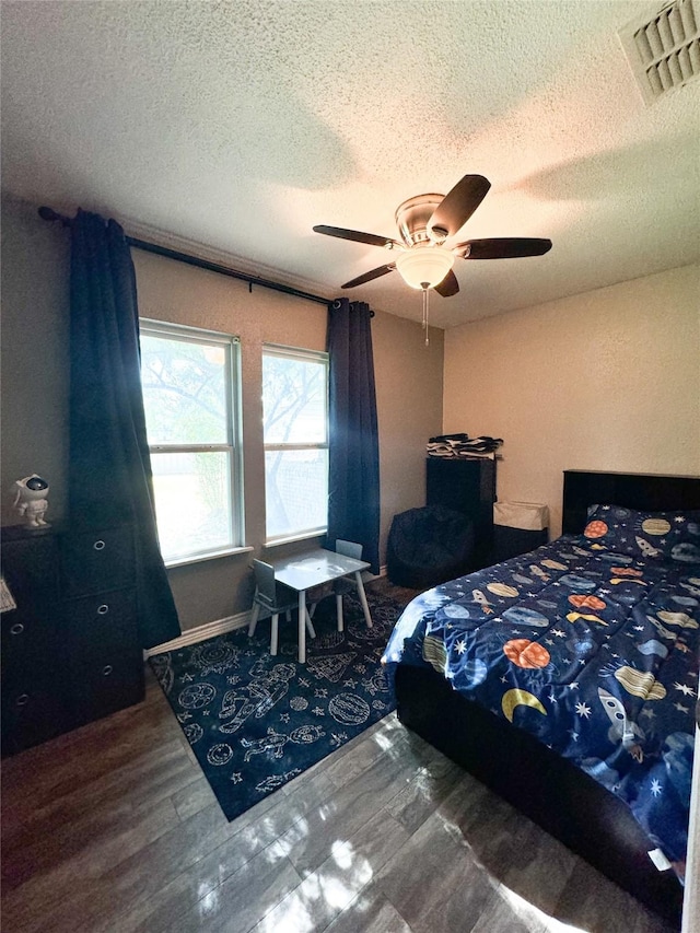 bedroom with a ceiling fan, a textured ceiling, and visible vents