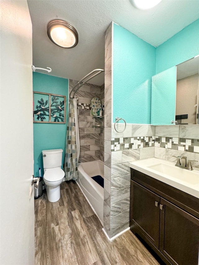 bathroom with wood finished floors, shower / bath combo with shower curtain, toilet, and vanity