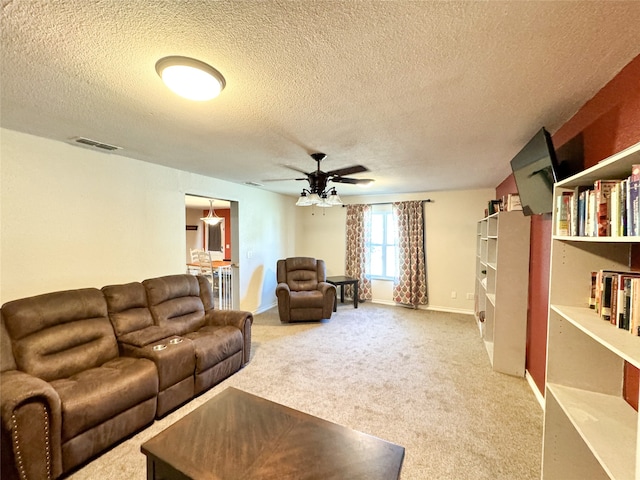 carpeted living room featuring ceiling fan and a textured ceiling