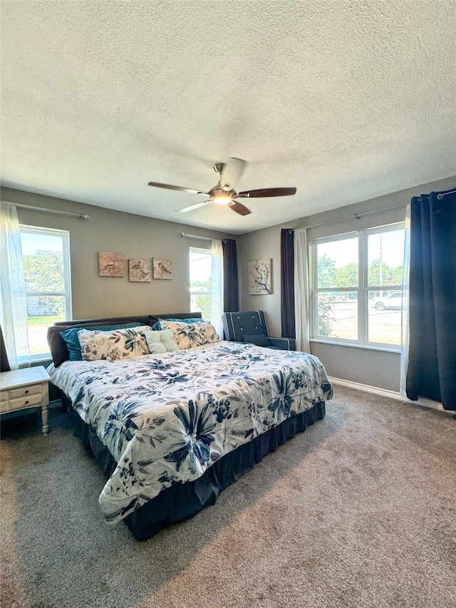 carpeted bedroom with a textured ceiling and ceiling fan