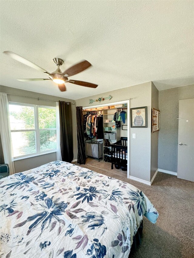 bedroom featuring a ceiling fan, carpet floors, a closet, baseboards, and a textured ceiling