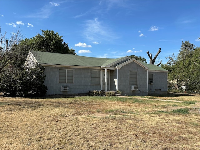 rear view of property featuring cooling unit, an AC wall unit, and a yard