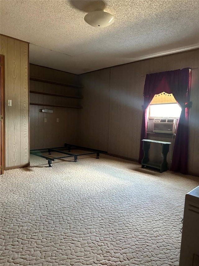 unfurnished room with cooling unit, a textured ceiling, and wooden walls