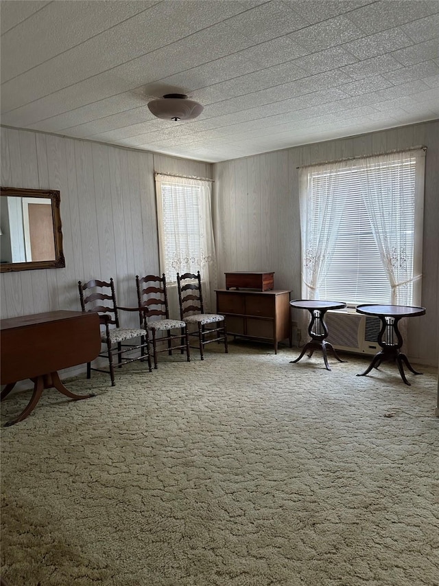 living area with plenty of natural light and carpet floors