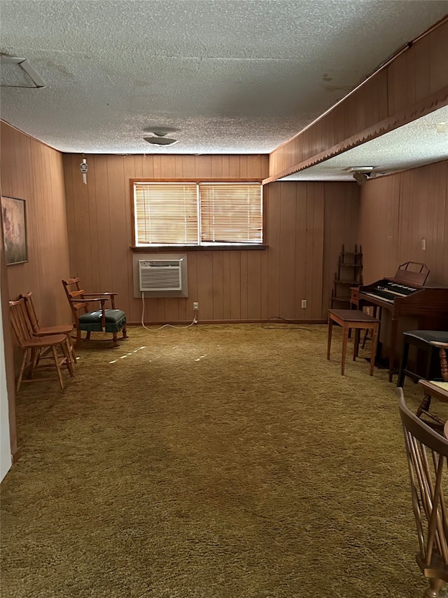 basement featuring carpet, an AC wall unit, wood walls, and a textured ceiling