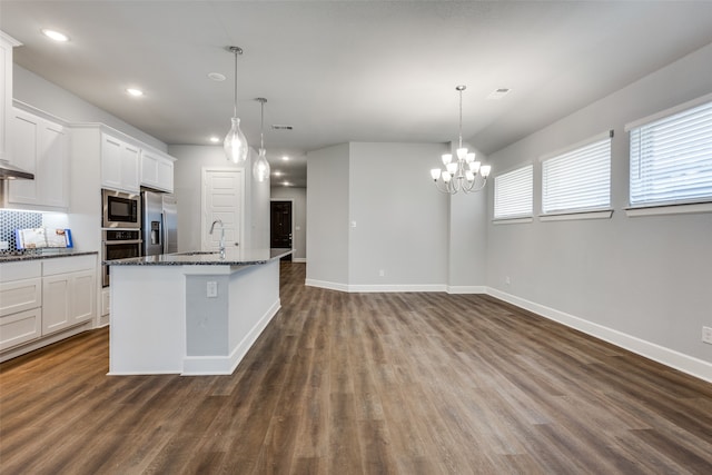 kitchen featuring stainless steel appliances, white cabinets, dark stone countertops, and dark hardwood / wood-style floors