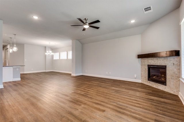 unfurnished living room with vaulted ceiling, sink, ceiling fan with notable chandelier, and dark hardwood / wood-style flooring