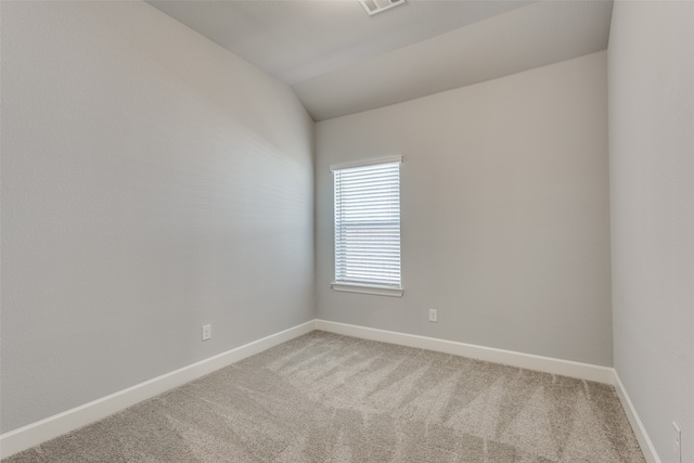 spare room with vaulted ceiling and carpet floors