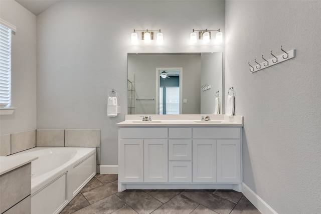 bathroom with ceiling fan, vanity, a bathing tub, and tile patterned floors