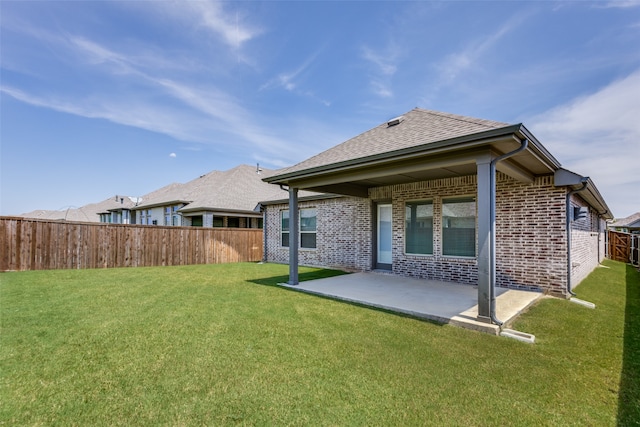 rear view of house with a lawn and a patio area