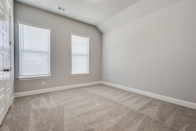 carpeted spare room featuring lofted ceiling