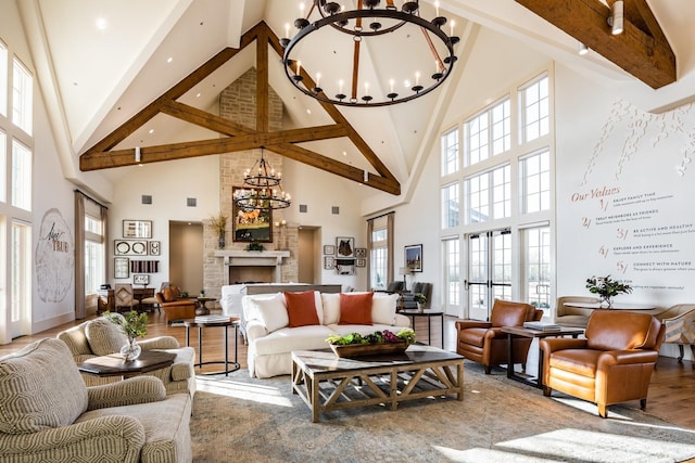 living room featuring high vaulted ceiling, plenty of natural light, a notable chandelier, and hardwood / wood-style flooring