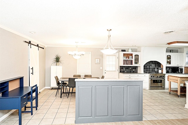 kitchen featuring high end range, hanging light fixtures, light tile patterned floors, a barn door, and white cabinets