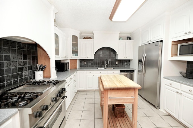 kitchen with tasteful backsplash, appliances with stainless steel finishes, and white cabinets