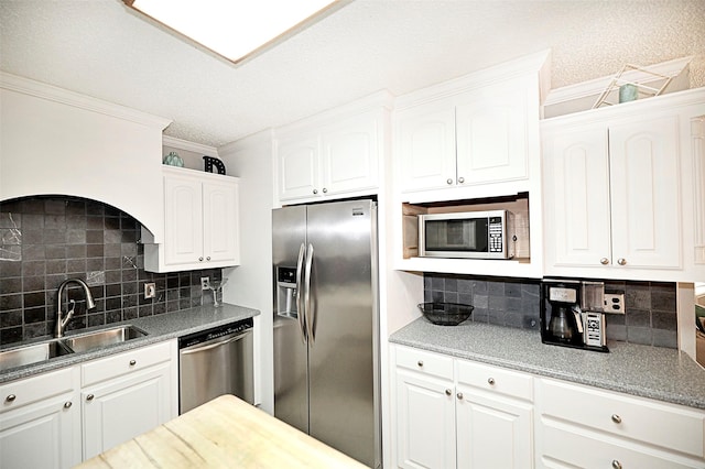 kitchen with stainless steel appliances, sink, and white cabinets