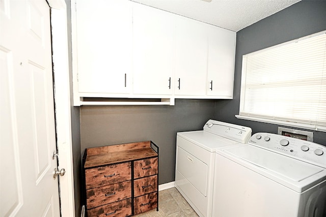 washroom with cabinets, washer and clothes dryer, and a textured ceiling