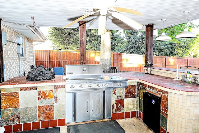 view of patio with exterior kitchen, an outdoor bar, and ceiling fan