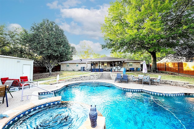 view of swimming pool featuring a shed, an outdoor hot tub, and a patio