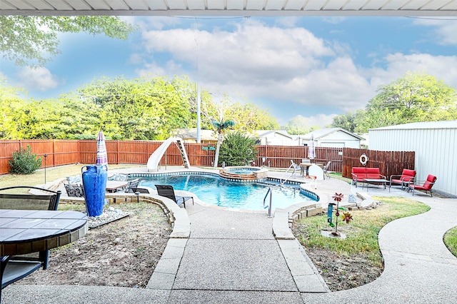 view of pool featuring a water slide, outdoor lounge area, a patio, and an in ground hot tub