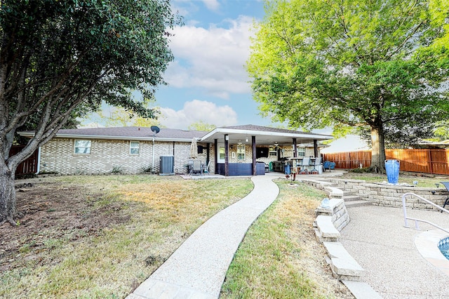 back of property with central AC unit, a yard, outdoor lounge area, and a patio