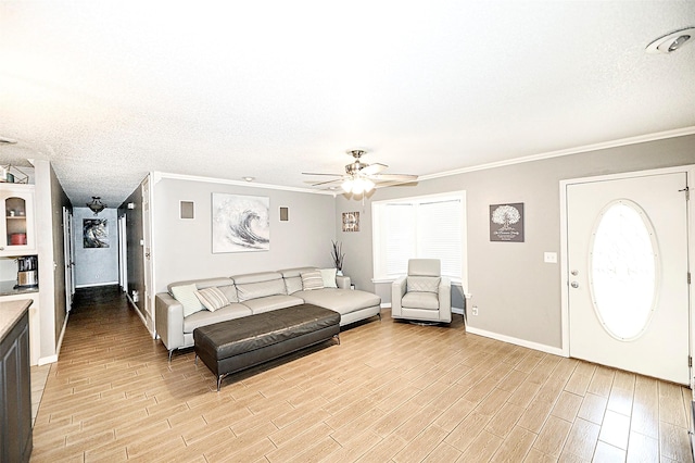 living room with crown molding, ceiling fan, plenty of natural light, a textured ceiling, and light wood-type flooring