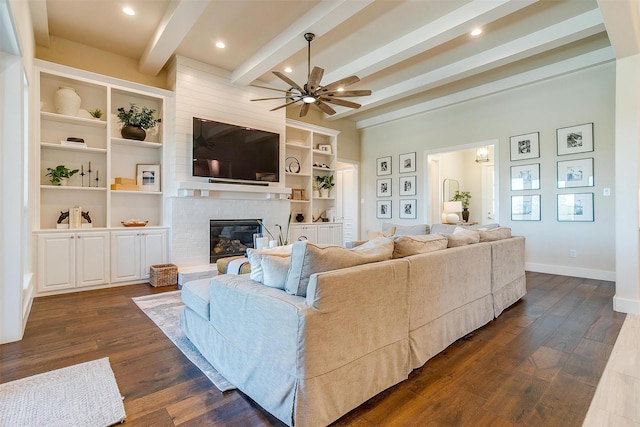 living room with a fireplace, ceiling fan, beamed ceiling, and dark hardwood / wood-style floors