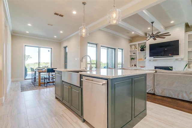 kitchen with dishwasher, a center island with sink, ceiling fan, a fireplace, and decorative light fixtures