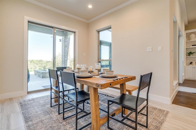 dining area featuring ornamental molding and light hardwood / wood-style floors