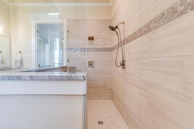 bathroom featuring a tile shower and crown molding