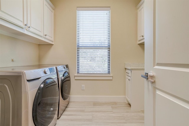 laundry room featuring washing machine and dryer and cabinets