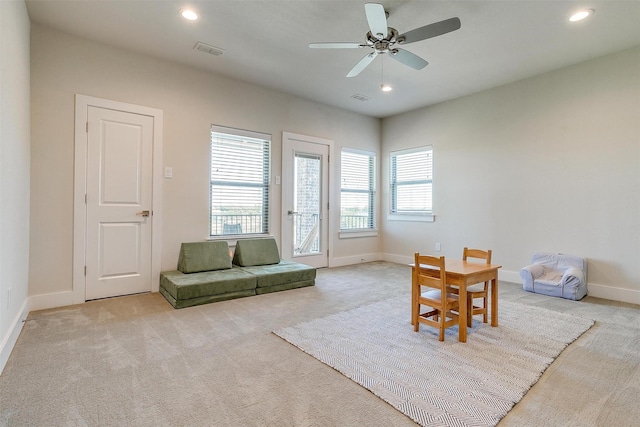 sitting room featuring ceiling fan and light carpet