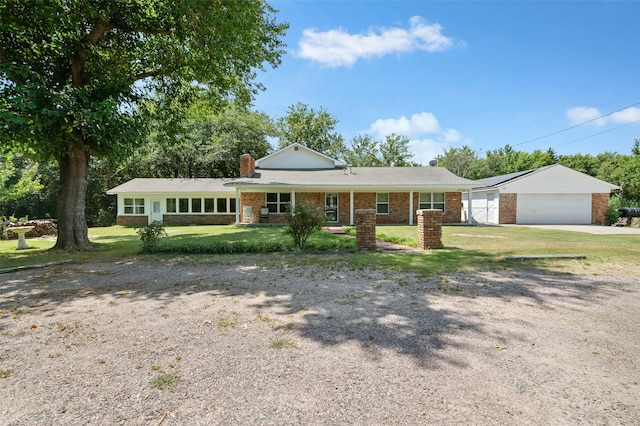 single story home featuring brick siding, a chimney, an attached garage, driveway, and a front lawn