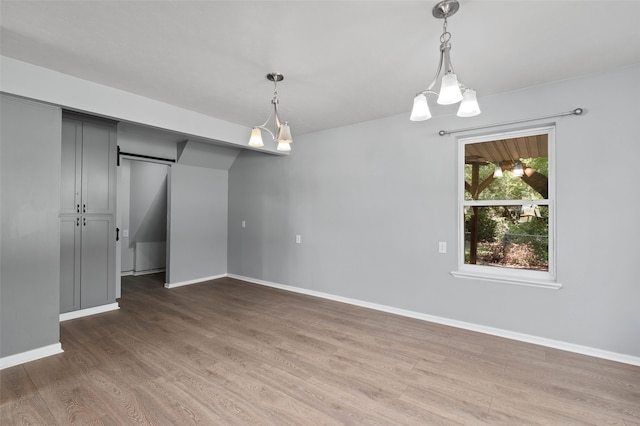 empty room featuring dark hardwood / wood-style floors and a notable chandelier