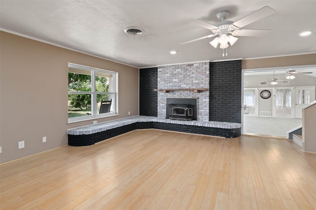 unfurnished living room featuring visible vents, crown molding, and wood finished floors