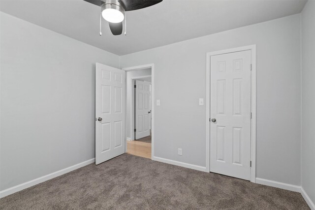 unfurnished bedroom featuring ceiling fan and carpet