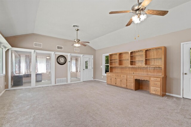 unfurnished living room with vaulted ceiling, light colored carpet, and ceiling fan