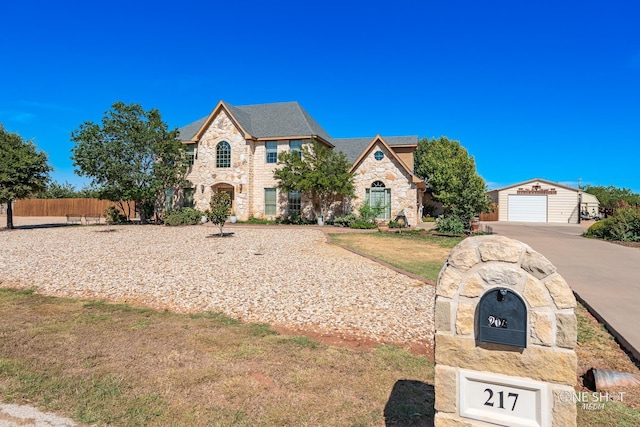 view of front of property with a garage, a front lawn, and an outdoor structure