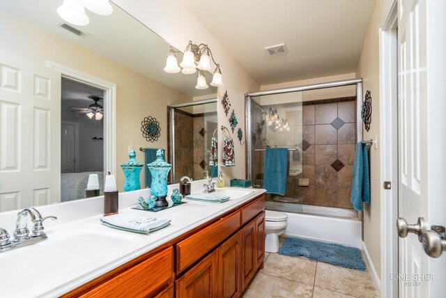 full bathroom with bath / shower combo with glass door, vanity, ceiling fan, tile patterned flooring, and toilet