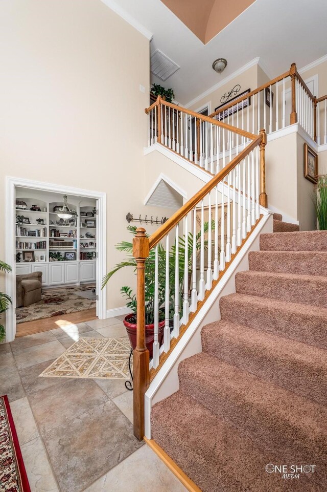 stairway featuring a high ceiling and ornamental molding