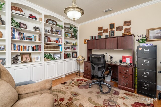 home office with light wood-type flooring and crown molding