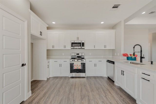 kitchen featuring sink, white cabinetry, light hardwood / wood-style floors, and stainless steel appliances