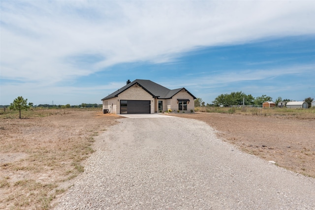 ranch-style house with a rural view and a garage