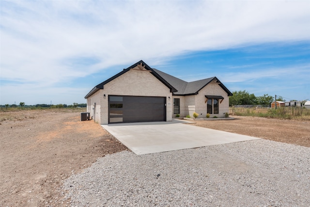 view of front of home featuring a garage and cooling unit