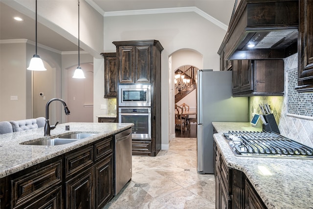 kitchen with backsplash, custom range hood, appliances with stainless steel finishes, light stone countertops, and sink