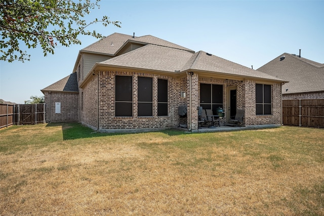 back of house with a patio and a yard