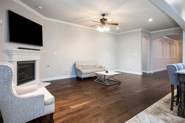 living room with hardwood / wood-style flooring, crown molding, and ceiling fan