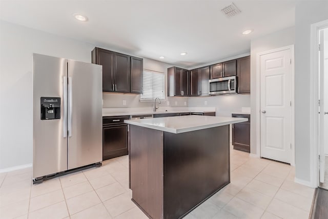 kitchen featuring appliances with stainless steel finishes, light countertops, dark brown cabinets, and a center island